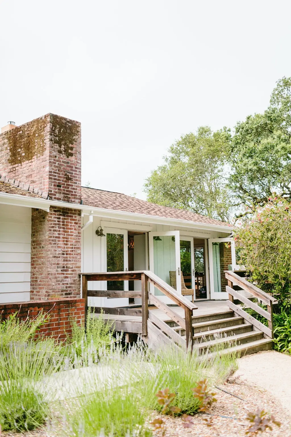 A landscape of the English countryside showing some flowers, a gated entry, and a small stone house. 